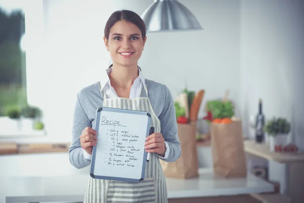 Vrouw in de keuken thuis, in de buurt van bureau met map — Stockfoto