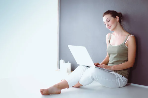 Retrato de uma menina sentada no chão e usando laptop — Fotografia de Stock