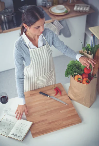 Mujer haciendo comida saludable de pie sonriendo en la cocina — Foto de Stock