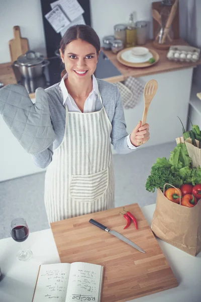 Mujer haciendo comida saludable de pie sonriendo en la cocina — Foto de Stock