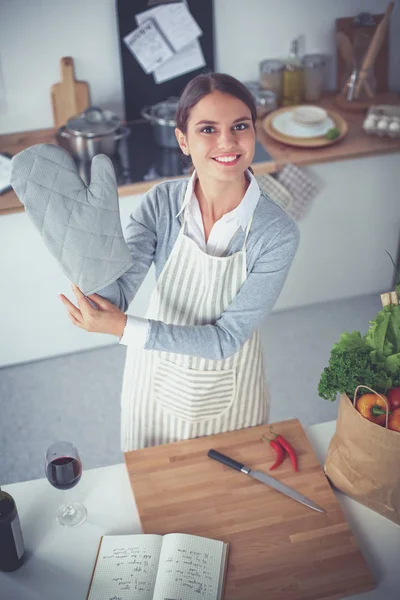 Mujer haciendo comida saludable de pie sonriendo en la cocina —  Fotos de Stock