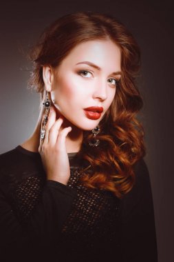 Siyah elbiseli, akşam makyajlı güzel bir kadın.