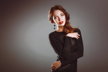 Siyah elbiseli, akşam makyajlı güzel bir kadın.