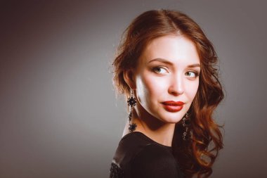 Siyah elbiseli, akşam makyajlı güzel bir kadın.