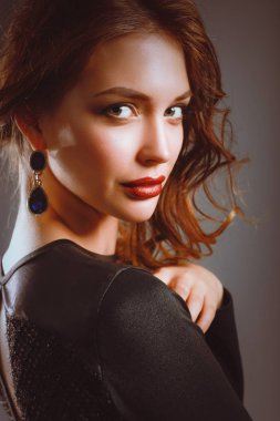 Siyah elbiseli, akşam makyajlı güzel bir kadın.