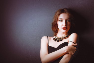 Siyah elbiseli, akşam makyajlı güzel bir kadın.