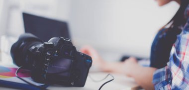Dizüstü bilgisayar ile masaya oturan kadın fotoğrafçı. Kadın fotoğrafçı