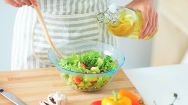 Genç kadın taze salata hazırlıyor.