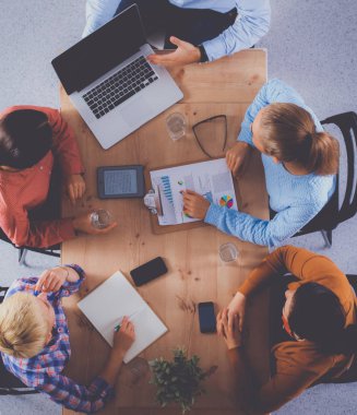 İş adamları iş toplantısında, ofiste oturup tartışıyorlar.