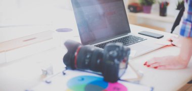 Dizüstü bilgisayar ile masaya oturan kadın fotoğrafçı. Kadın fotoğrafçı