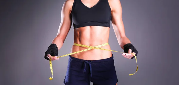 Fitness womans beautiful body with measure tape — Stock Photo, Image