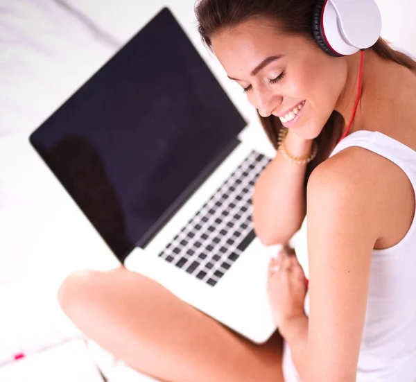 Giovane bella donna a letto ad ascoltare musica . — Foto Stock