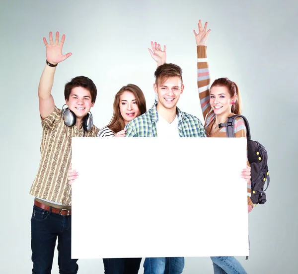 若い友人のグループは、白い背景に隔離された空白の板を保持する。 — ストック写真