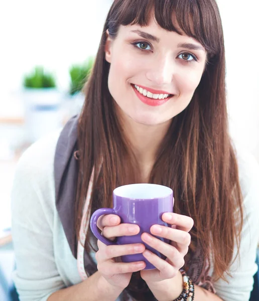 Moderno diseñador de moda joven con taza en el estudio — Foto de Stock