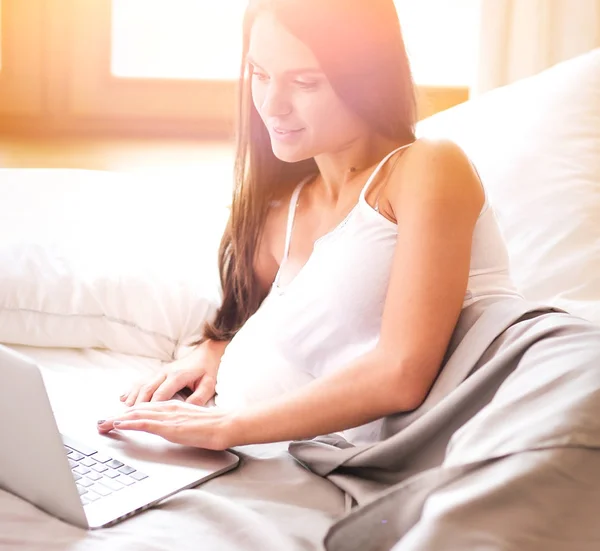 Hermosa morena acostada en la cama en casa — Foto de Stock