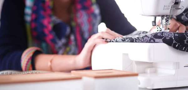 Young woman sewing while sitting at her working place . — Stock Photo, Image