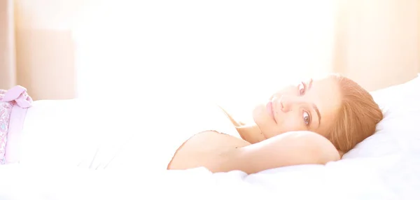 A beautiful young woman lying in bed comfortably and blissfully. — Stock Photo, Image