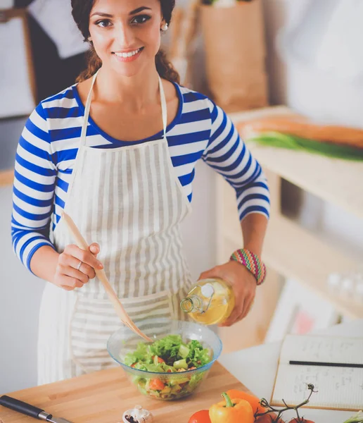 Mujer joven sonriente mezclando ensalada fresca — Foto de Stock