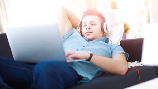 Young man sitting on chair with laptop — Stock Photo, Image