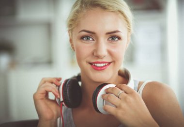 Evdeki genç ve güzel kadın kanepede oturup müzik dinliyor.