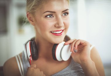 Evdeki genç ve güzel kadın kanepede oturup müzik dinliyor.