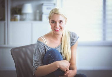 Genç ve güzel bir kadın odasında kanepede oturuyor.