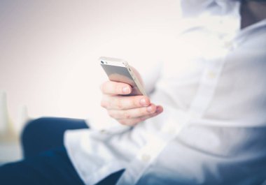 Yakışıklı genç adam akıllı telefon evde kullanma