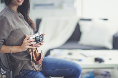 Dizüstü bilgisayar ile masaya oturan kadın fotoğrafçı. Kadın fotoğrafçı