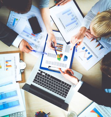 İş adamları toplantıda, ofiste oturup tartışıyorlar.