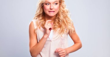 Gri arka planda soyutlanmış genç, duygusal bir kadın.