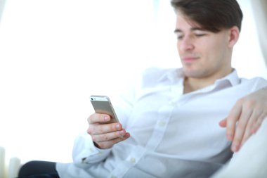Yakışıklı genç adam akıllı telefon evde kullanma