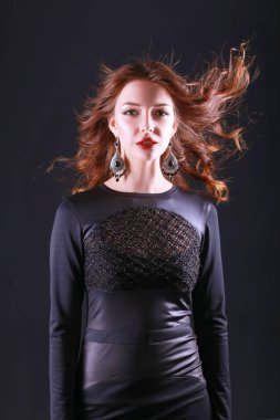 Siyah elbiseli, akşam makyajlı güzel bir kadın.