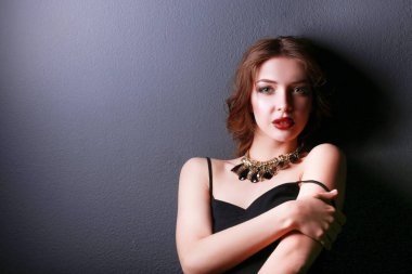 Siyah elbiseli, akşam makyajlı güzel bir kadın.