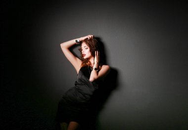 Siyah elbiseli, akşam makyajlı güzel bir kadın.