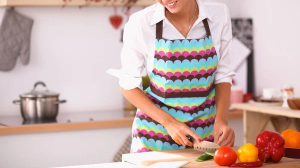 Leende kvinna tillagar sallad i köket — Stockfoto