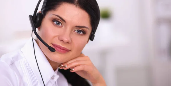 Retrato de una hermosa mujer de negocios trabajando en su escritorio con auriculares y laptop — Foto de Stock