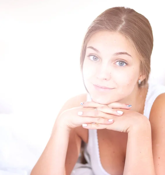 Una hermosa joven acostada en la cama cómoda y felizmente. — Foto de Stock