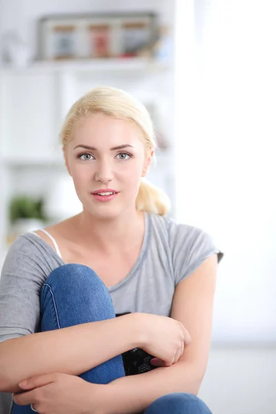 Ung vacker kvinna sitter på soffan på sitt rum — Stockfoto