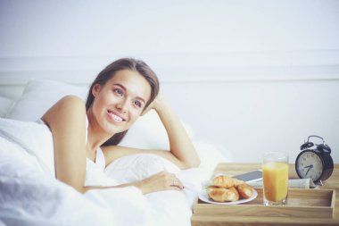 Evde yatakta yatan genç güzel kadın.