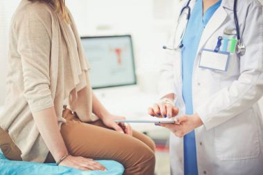 Doktor ve hasta masada otururken bir şey tartışıyorlar. Tıp ve sağlık hizmetleri kavramı. Doktor ve hasta.