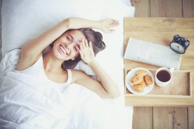 Genç ve güzel bir kadın yatakta yatıyor..