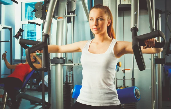 Beautiful girl at the gym exercising on trainers. Beautiful girl — Stock Photo, Image