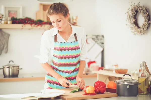 Femme souriante tenant son téléphone portable dans la cuisine. Femme souriante . — Photo