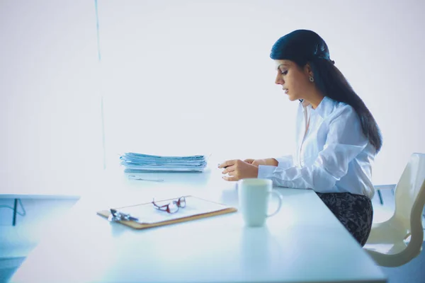 机の上に座っている書類を持つ女性 — ストック写真