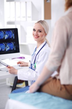 Doktor ve hasta masada otururken bir şey tartışıyorlar. Tıp ve sağlık hizmetleri kavramı. Doktor ve hasta.