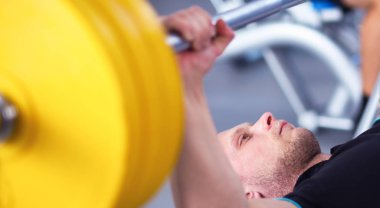 Genç adam eğitmen ile spor salonunda halter kaldırma