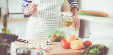 Genç kadın taze salata hazırlıyor.