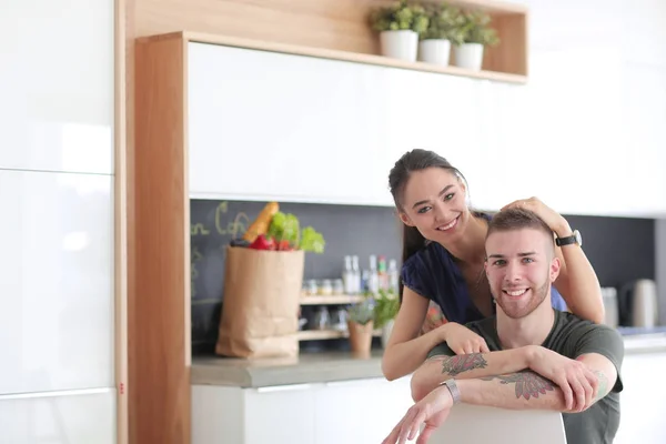 Belo jovem casal está se divertindo na cozinha em casa — Fotografia de Stock