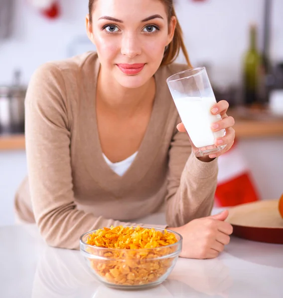 Sorridente donna attraente che fa colazione in cucina interna — Foto Stock