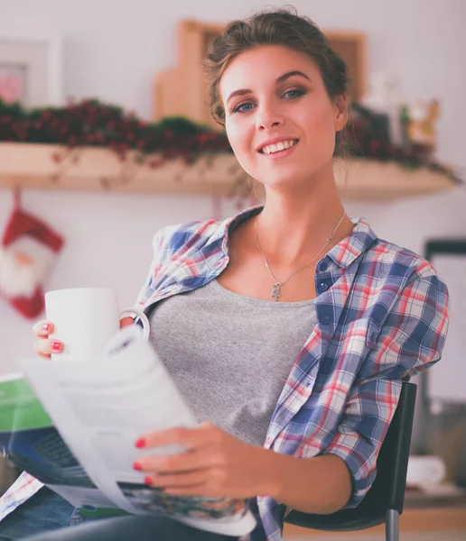 Frau liest Magazin in der Küche zu Hause — Stockfoto